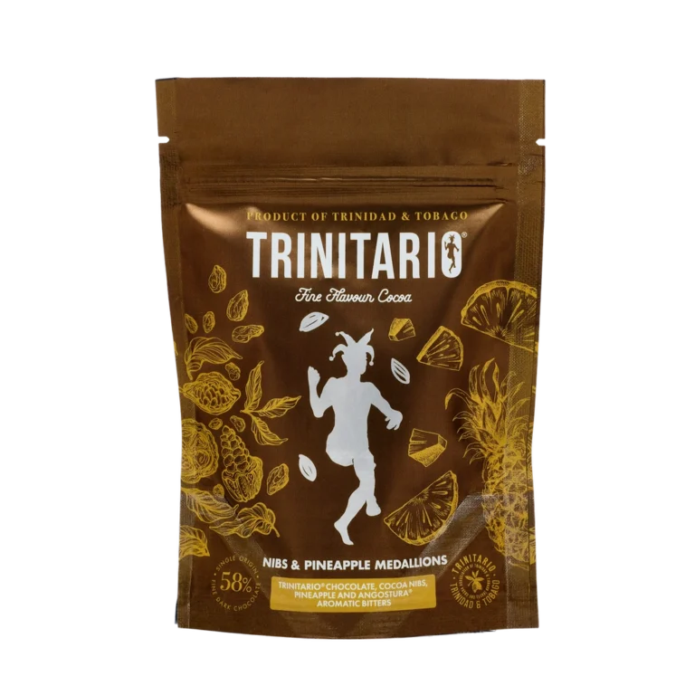 A brown pouch labelled “Trinitario Fine Flavour Cocoa” featuring gold illustrations of cocoa and pineapples, contains handcrafted chocolate nibs and pineapple medallions. | Trinitario