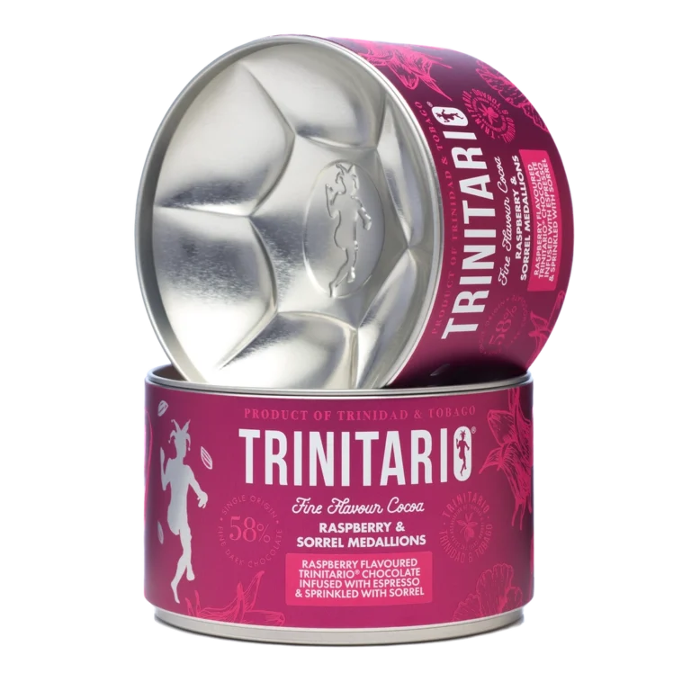 A cylindrical tin of Trinitario chocolate raspberry and sorrel medallions, crafted from fine flavour cocoa, partially opened to reveal the medallion-shaped interior. | Trinitario