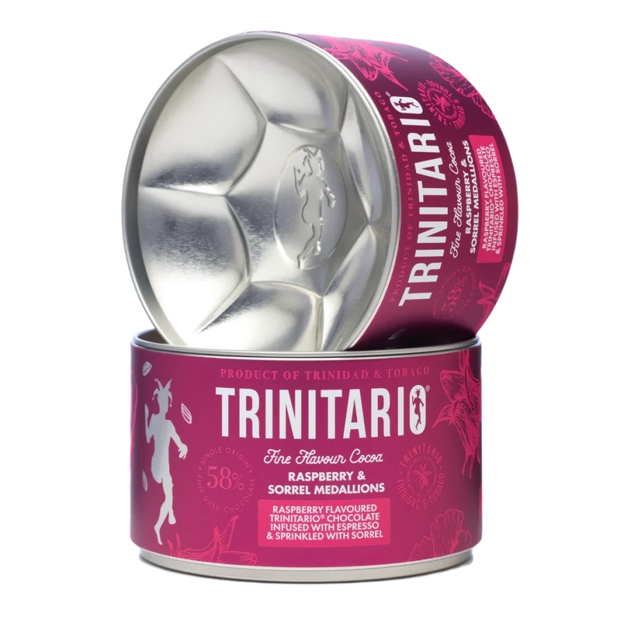 A cylindrical tin of Trinitario chocolate raspberry and sorrel medallions, crafted from fine flavour cocoa, partially opened to reveal the medallion-shaped interior. | Trinitario