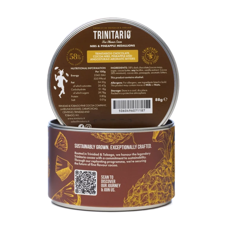 A cylindrical tin labelled "Trinitario Nibs & Pineapple Medallions" features nutritional information, a QR code, and highlights its use of Caribbean cocoa for a richly authentic, fine flavour cocoa experience. | Trinitario