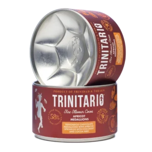Round tin of handcrafted Trinitario chocolate apricot medallions, labelled as 58% dark chocolate with apricot, coconut, and cocoa nibs. Product of Trinidad & Tobago. One tin is open and tilted on another. | Trinitario