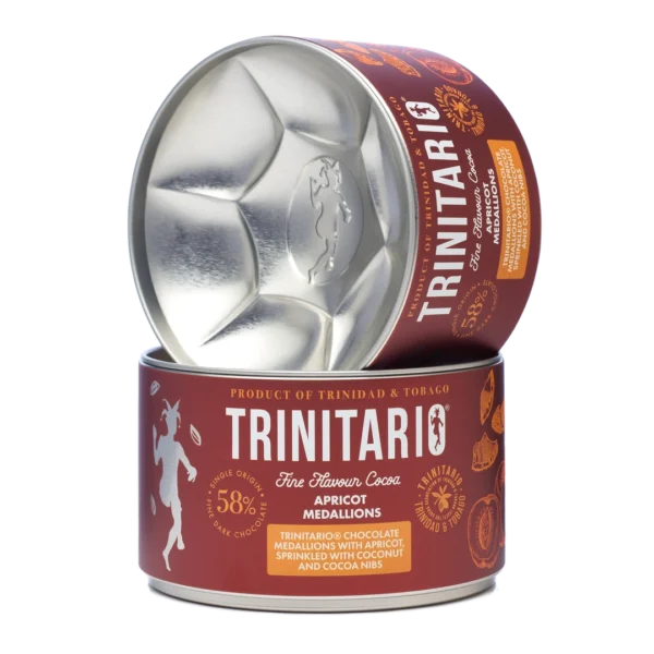 Round tin of handcrafted Trinitario chocolate apricot medallions, labelled as 58% dark chocolate with apricot, coconut, and cocoa nibs. Product of Trinidad & Tobago. One tin is open and tilted on another. | Trinitario