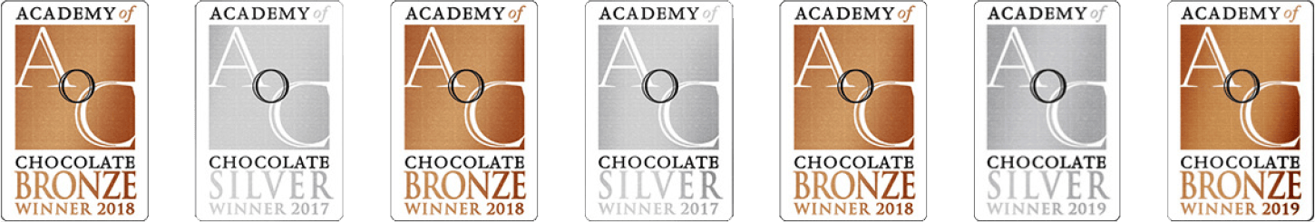 Seven Academy of Chocolate award badges are displayed in a row, alternating between bronze and silver winners from 2017 to 2019, celebrating our single-origin chocolate crafted from the finest Caribbean cocoa. | Trinitario