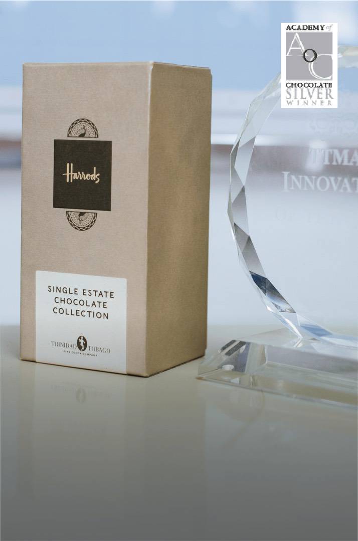 A Harrods Single Estate Chocolate Collection box, made with fine flavour cocoa, stands next to a crystal award with an Academy of Chocolate Silver Winner sticker in the top right-hand corner. | Trinitario
