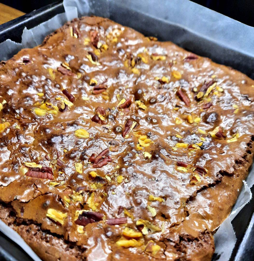Chocolate brownie with chopped nuts in baking tin